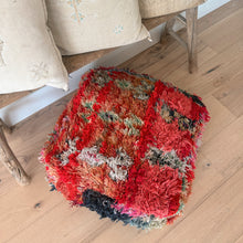 Load image into Gallery viewer, Colorful textured rug on a wooden floor with a chair and pillows in the background