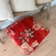 Load image into Gallery viewer, Red patterned footstool on a wooden floor with pillows in the background