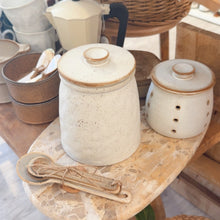 Load image into Gallery viewer, Set of ceramic jars with wooden lids on a wooden table with wicker basket in the background.