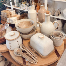 Load image into Gallery viewer, Display of ceramic kitchenware on a wooden table with shelves in the background
