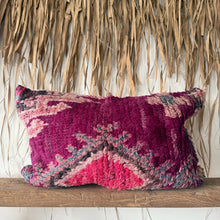 Load image into Gallery viewer, Decorative pillow with a pink and purple pattern on a wooden shelf against a thatched wall.
