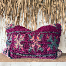 Load image into Gallery viewer, Decorative pillow with a colorful pattern on a wooden shelf against a thatched roof background
